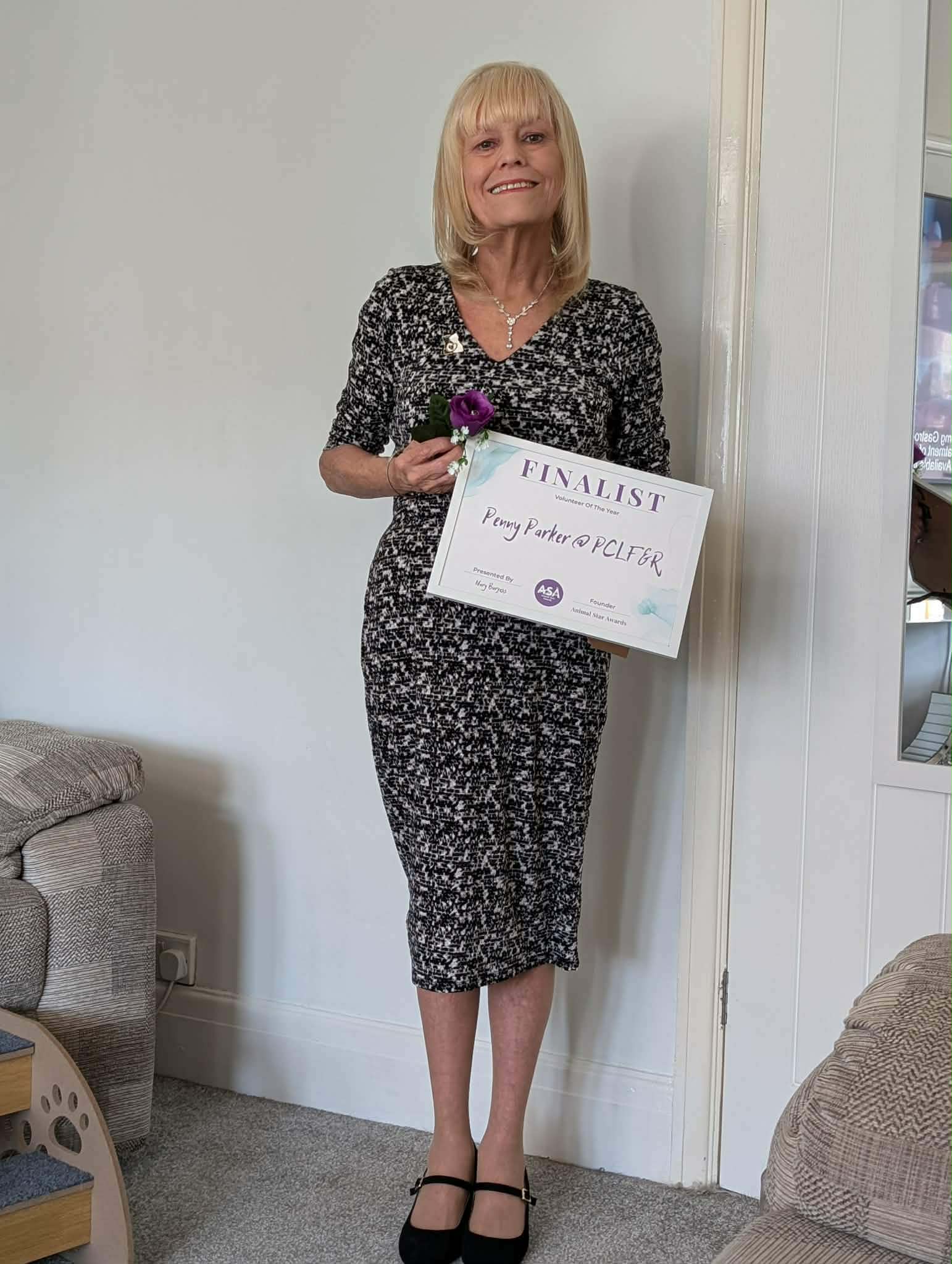 Penny Parker holding her Volunteer of the Year finalist certificate from the Animal Star Awards